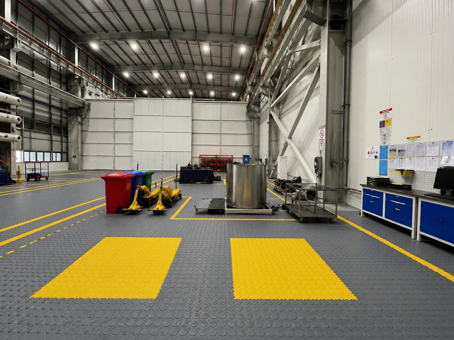 Home 1 Tiepro interlocking PVC floor tiles dominating a high-bay manufacturing facility with colour-zoned safety lanes