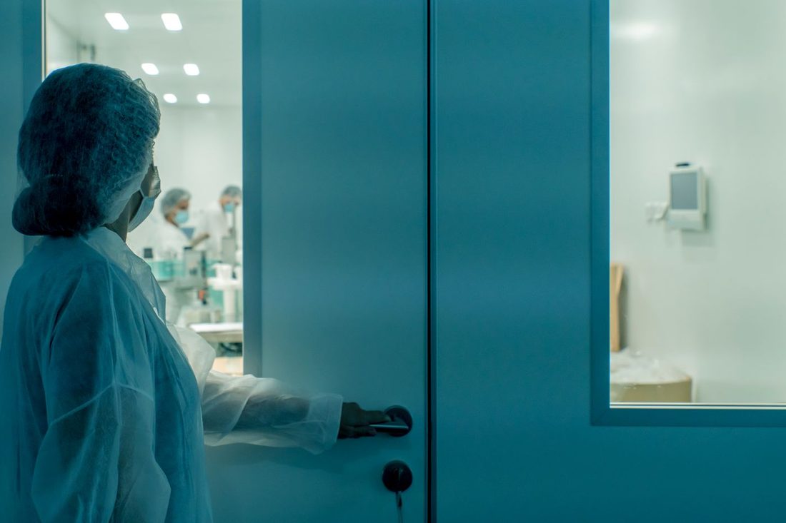 Home 13 Technician entering a pharmaceutical clean room in PPE